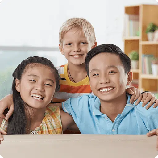 three children near a desk with books on background