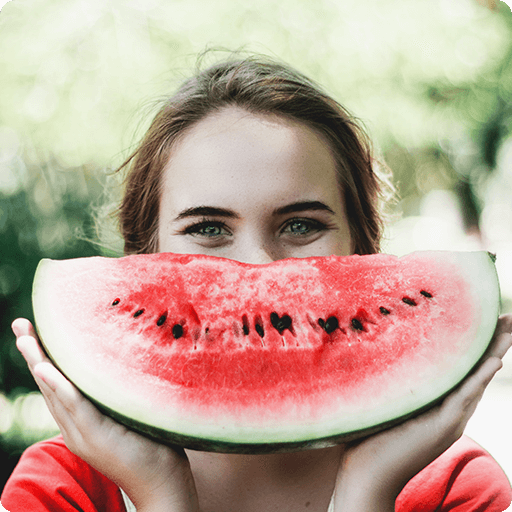 girl holding watermelon to her face