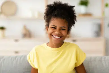 girl with yellow shirt smiling