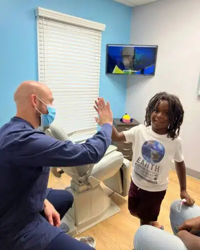 Dr. Milo from Front Row Pediatrics high fiving patient
